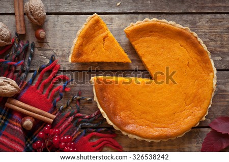 Sweet delicious natural pumpkin tart pie dessert sliced on vintage wooden table background. Autumn color composition. Rustic style and natural light.
