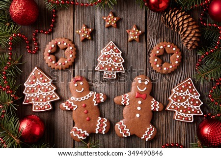 Gingerbread man and woman, fir, stars, christmas cookies composition with xmas tree decoration on vintage wooden table background. Homemade traditional new year dessert food recipe
