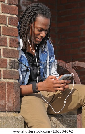 young black man listening to music on his smart phone