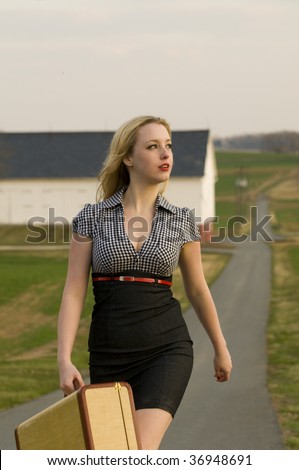 woman walking away with a suitcase in the Pennsylvania country side