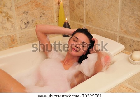 relaxed woman enjoying a warm bubble bath at home