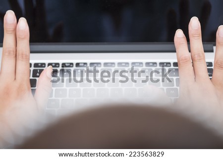 Beautiful woman\'s fingers up on laptop computer. High angle view on woman\'s hands ready typing. Color image and closeup
