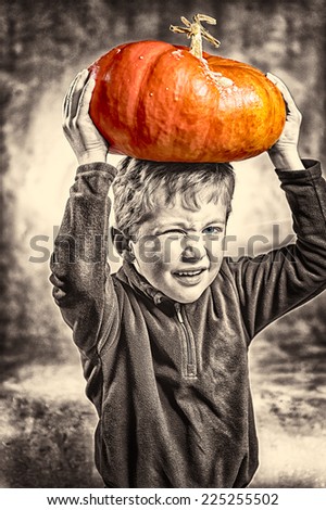 Portrait of little boy making a face with heavy orange pumpkin hat. Halloween theme. Studio shoot after freshly harvest in autumn. Mixed sepia and color image