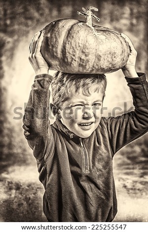 Portrait of little boy making a face with heavy ripe pumpkin hat. Halloween theme. Studio shoot after freshly harvest in autumn. Sepia toned