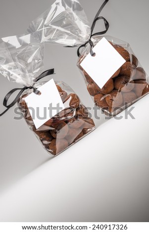 Fun Christmas gifts. Two luxury plastic bags with black ribbons of chocolate truffles and copy space. Blank label  that you can add your own trademark or your own message. Shooting in studio.