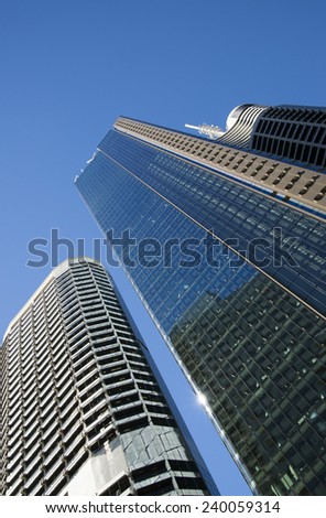 perspective view to steel light blue background of glass high rise building skyscraper commercial modern city