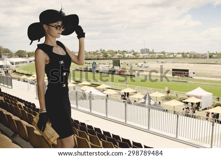 beautiful lady in a proper outfit for horse racing day on the Melbourne Cup event on hippodrome, fashion on the field