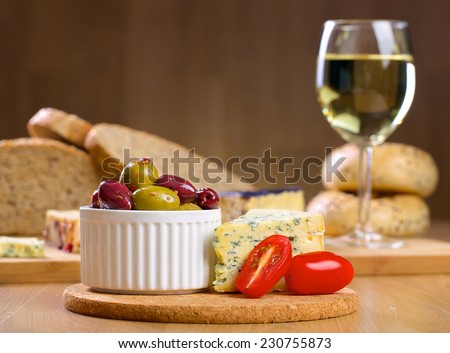 Roquefort cheese, olives and tomatos on a wooden serving board