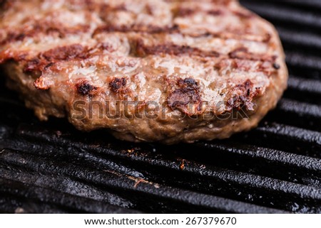 Preparing a batch of ground beef patties or frikadeller on grill or BBQ