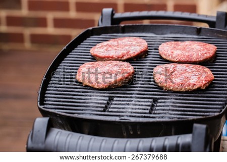 Preparing a batch of ground beef patties or frikadeller on grill or BBQ