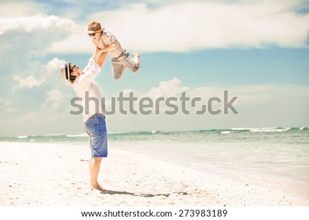 Happy father and son enjoying beach time on summer vacation in a sunny day