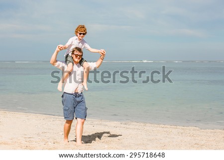 Hipster father with beard and red haired son having great happy time at a summer day. Vacation, happy and friendly family, holidays concept