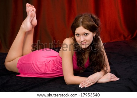 The girl poses laying on a floor in studio