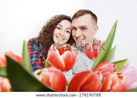 happy woman and a man in a shirt with a bouquet of flowers on a