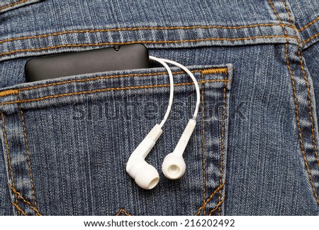 headphones and mobile phone in the pocket of jeans