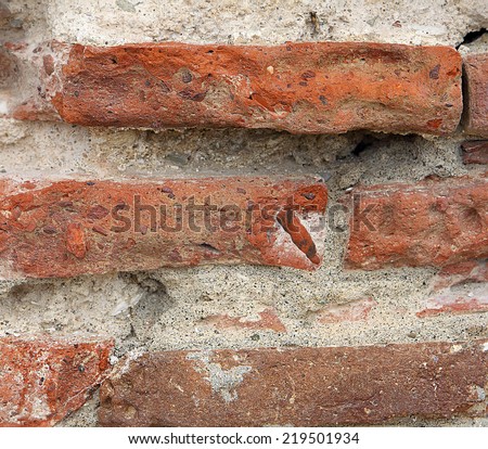 small part broken brick wall that is part of an old house