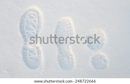 Traces of shoes of different sizes on the snow