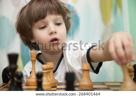 Portrait of a little boy playing chess