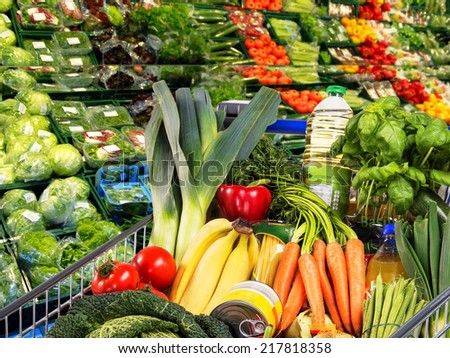 Shopping cart with fruit and vegetables in the supermarket.