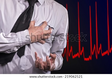 Business man thumbs up with a cramped hand to his heart: He has a heart attack.