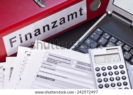 File folder labeled Finanzamt (tax office), forms, calculators and a computer as a symbol for the preparation of the tax return.