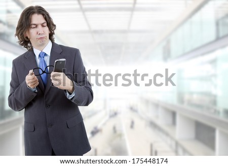 young business man looking worried to his phone, at the office