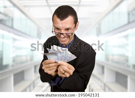 Greedy business man with money at the office