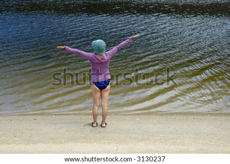 happy woman with arms wide open at the coast