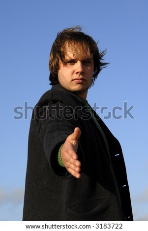 young man offering hand with the sky as background