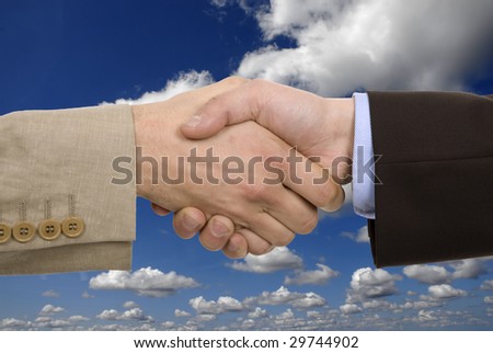 Business team hand shake with the sky as background
