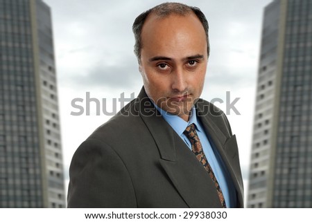 mature business man standing with two office building behind