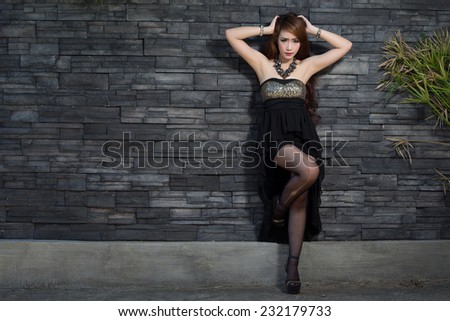 Young beautiful Asian model wearing black dress