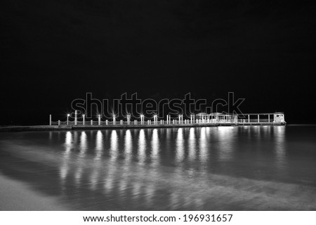 Description:  Night black and white photograph of the Waikiki Boat Pier.\
Title:  Waikiki boat landing.