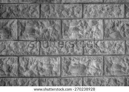 Rough carved granite block exterior wall photographed in black and white.