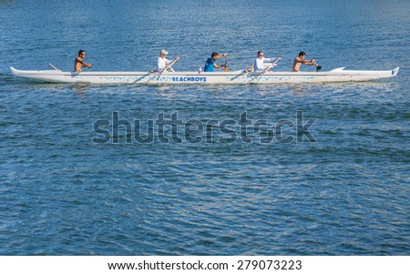 Honolulu, Hawaii, USA, May 18, 2015:  Outrigger canoe team practicing for a competition in front of the world famous Waikiki Beach.  Outrigger canoe competition draws international entries in June.