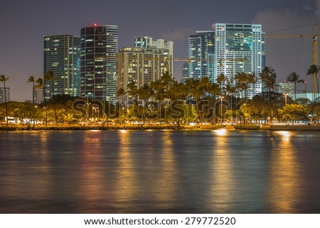 Honolulu, Hawaii, USA, May 21, 2015: The Honolulu cityscape on a windy night.  Numerous construction cranes point to additional high rise condominiums in the future for Honolulu residents.