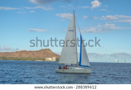 Honolulu, Hawaii, USA, June 18, 2015:  A sailboat takes a group of passengers out for a there hour tour in Waikiki.  This will be the finish point for the upcoming 2015 Transpacific Sailboat Race.