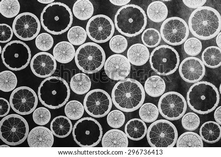 Fruit background made of lemon, lime, orange,and grapefruit slices in tones of black, white, and gray.