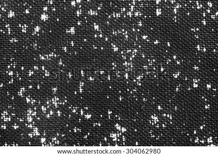 Vintage cloth fragment with white irregular dots against a black background.