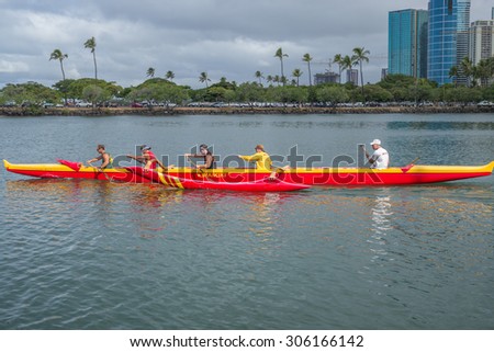 Honolulu, Hawaii, USA, August 14, 2015: Morning view of an colorful outrigger canoe and crew heading out of the Ala Wai Harbor for a paddle. The Ala Wai Harbor is the largest pleasure harbor in Hawaii