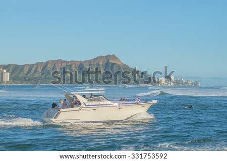 Honolulu, Hawaii, USA, Oct. 26, 2015:  Afternoon view of a luxury power boat cruising the waters of Waikiki.  Exclusive dinner cruises are a growing trend for wealthy Honolulu tourists.