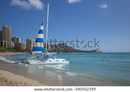 Honolulu, Hawaii, USA, Nov. 17, 2015:  Tourist Beach Catamaran Business on Waikiki Beach with the point of focus on the beach catamaran.  Beach cats are a popular business in Hawaii.