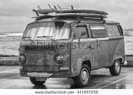 Honolulu, Hawaii, USA, Nov. 21, 2015: Morning  Waikiki view of an antique surf van in a rain shower.  Old surf vans are popular in Waikiki as transportation and camping accommodations.