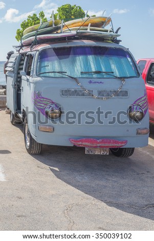 Honolulu, Hawaii, USA, Dec. 11, 2015:  Profile view of an old Waikiki surf van on the beach with six classic surfboards on top.  Vintage surfing vans are popular in Honolulu.