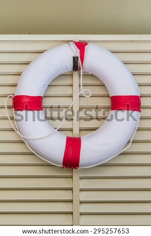 White life-buoy hanging on wooden wall