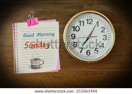 The paper wrote Good Morning Sunday with seven o\'clock hanging on the wooden wall.