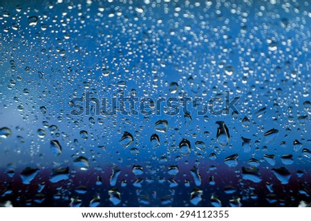 blurred bokeh and water drops on blue mirror background