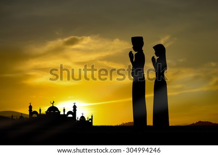 Silhouette muslim people praying at sunset.