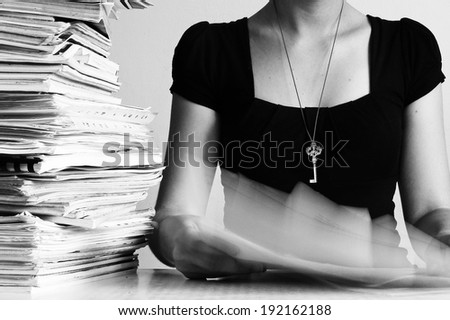 A workaholic surrounded by paper with the key to success around her neck