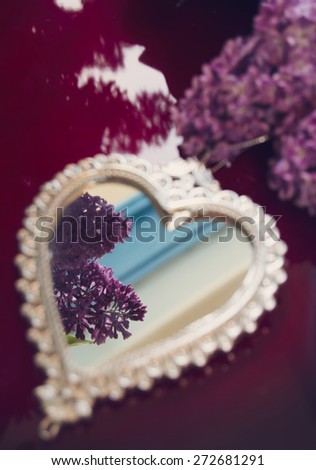 Elegant heart-shaped mirror and lilac flowers